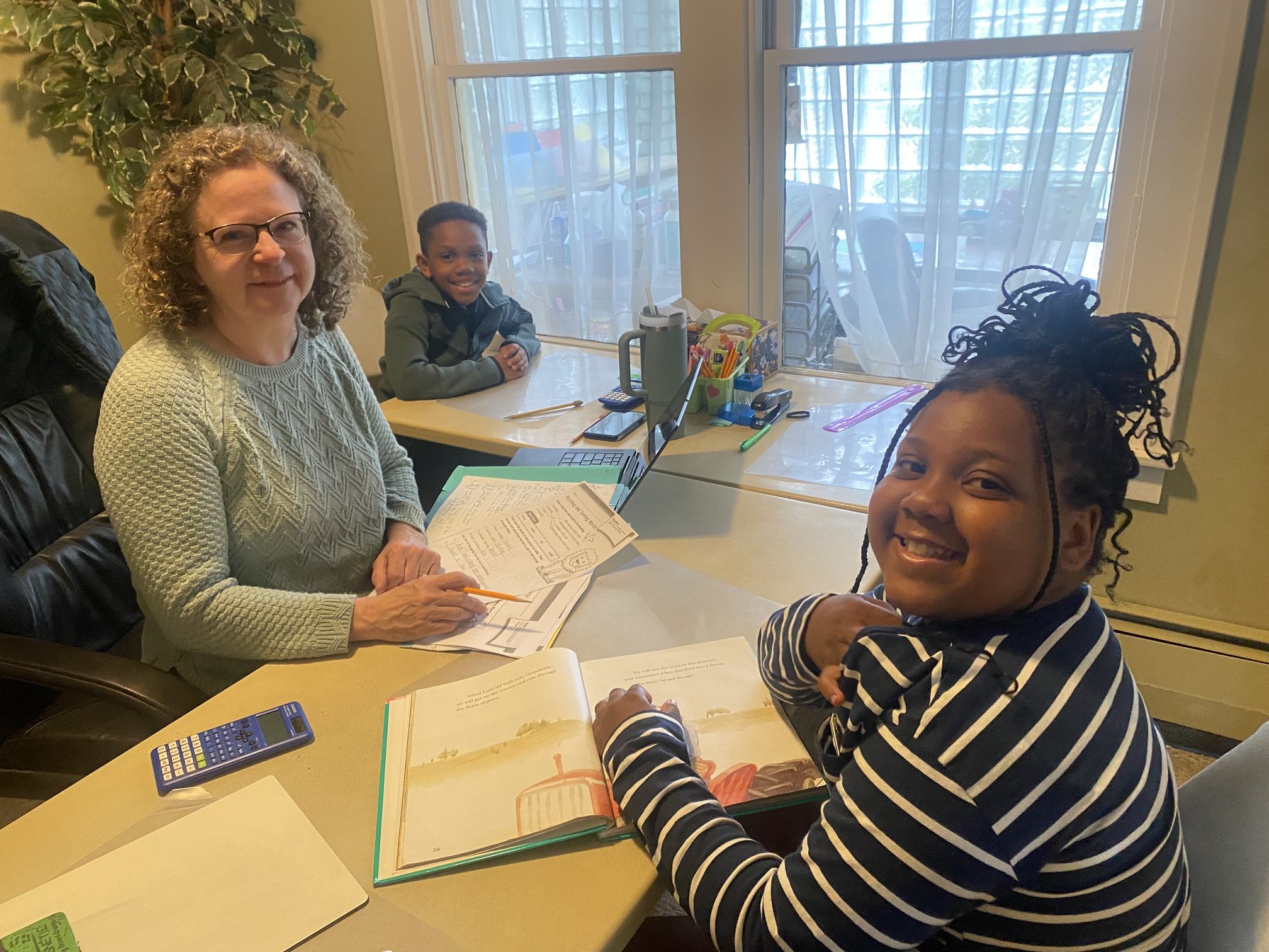 A tutor and two students by window